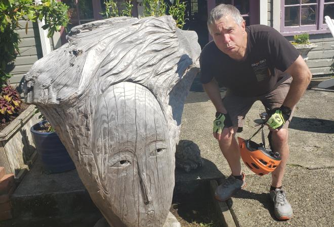David making a face next to carved wooden head