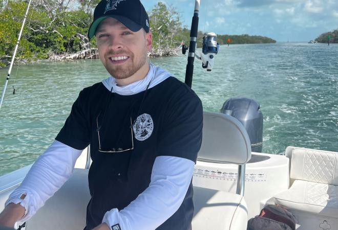 Kyle Pote GIS Analyst at MFA driving a fishing boat