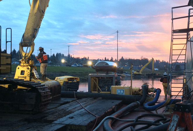 excavator on river at sunset